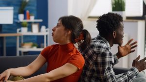 casal-interracial-irritado-brigando-no-sofa_482257-23111